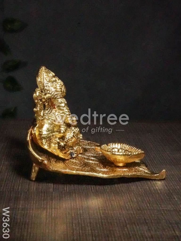 White Metal Ganesha in Pipal Leaf with Diya Gold Finish - W3630