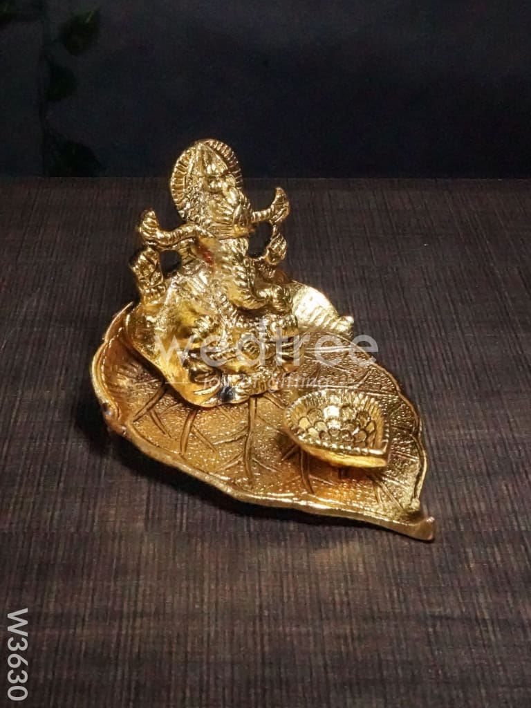 White Metal Ganesha in Pipal Leaf with Diya Gold Finish - W3630